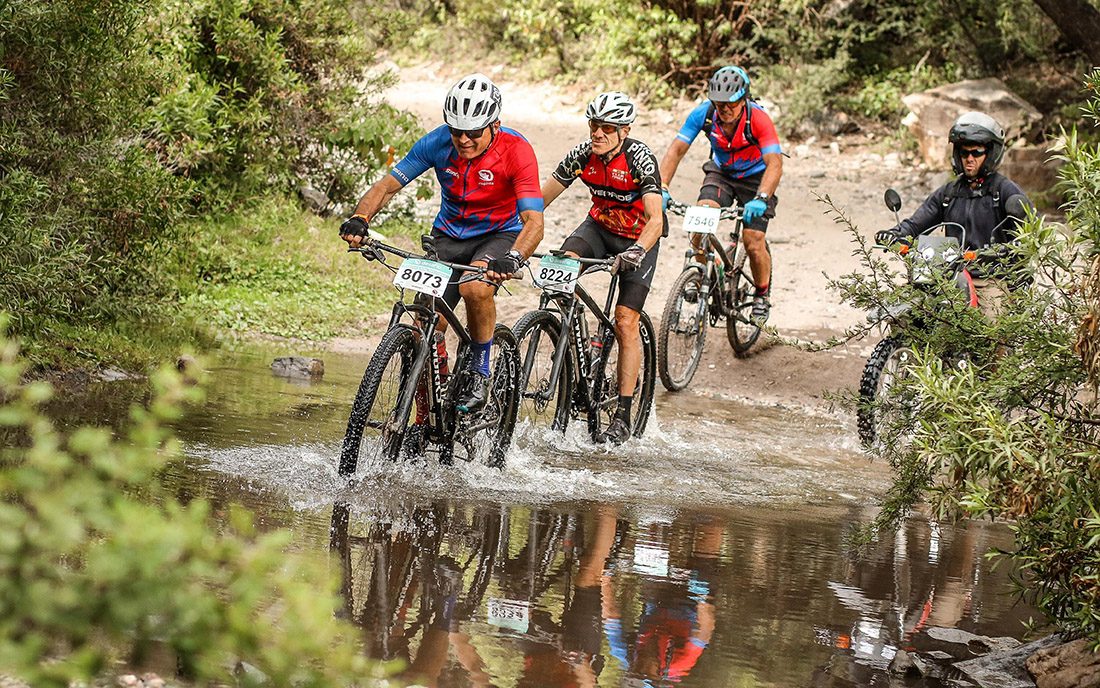 Ciclistas de mountain bike por un sendero con agua