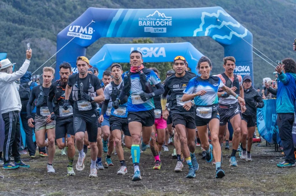 Corredores y público bajo el arco del UTMB en el Centro Cívico de Bariloche