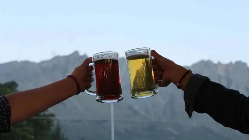 Brindis con dos jarros de cerveza frente a la montaña