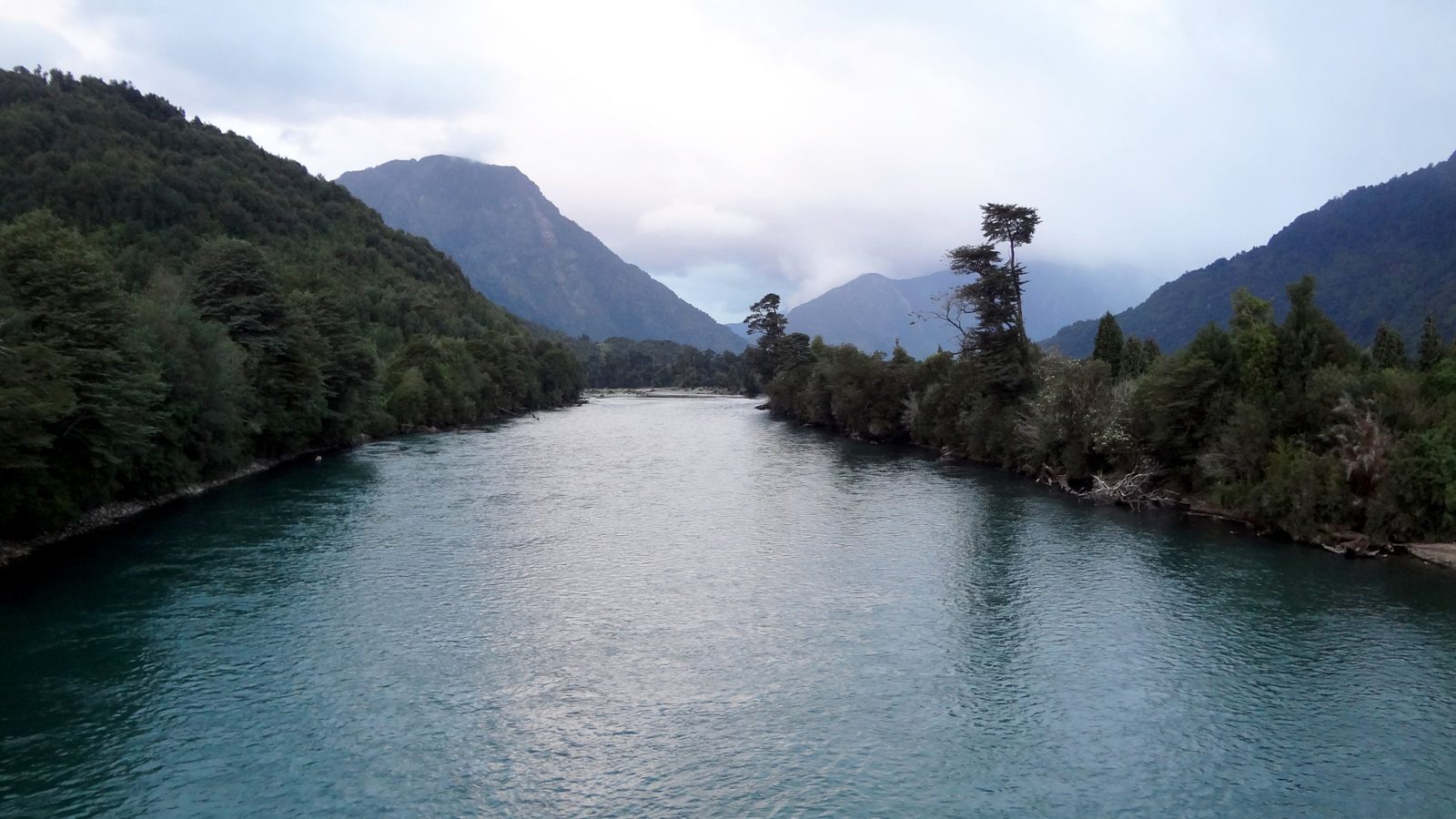 Río de aguas turquesa entre cerros cubiertos de bosque