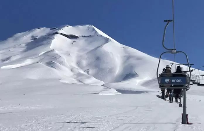 Volcán Lonquimay nevado y una silla de andarivel en Corralco